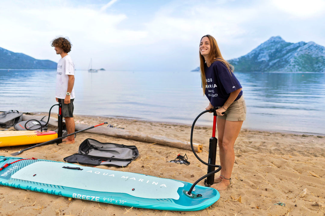 Inflating the Aqua Marina Breeze SUP on the beach with the included hand pump