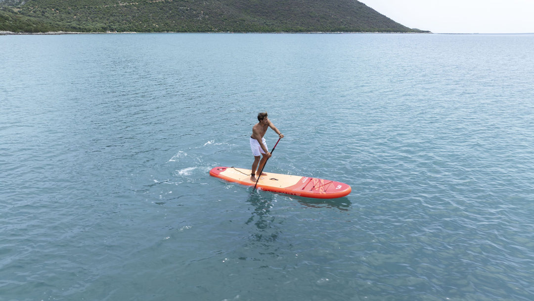 Paddling the red Aqua Marina Monster 12'0" paddle board along the coast
