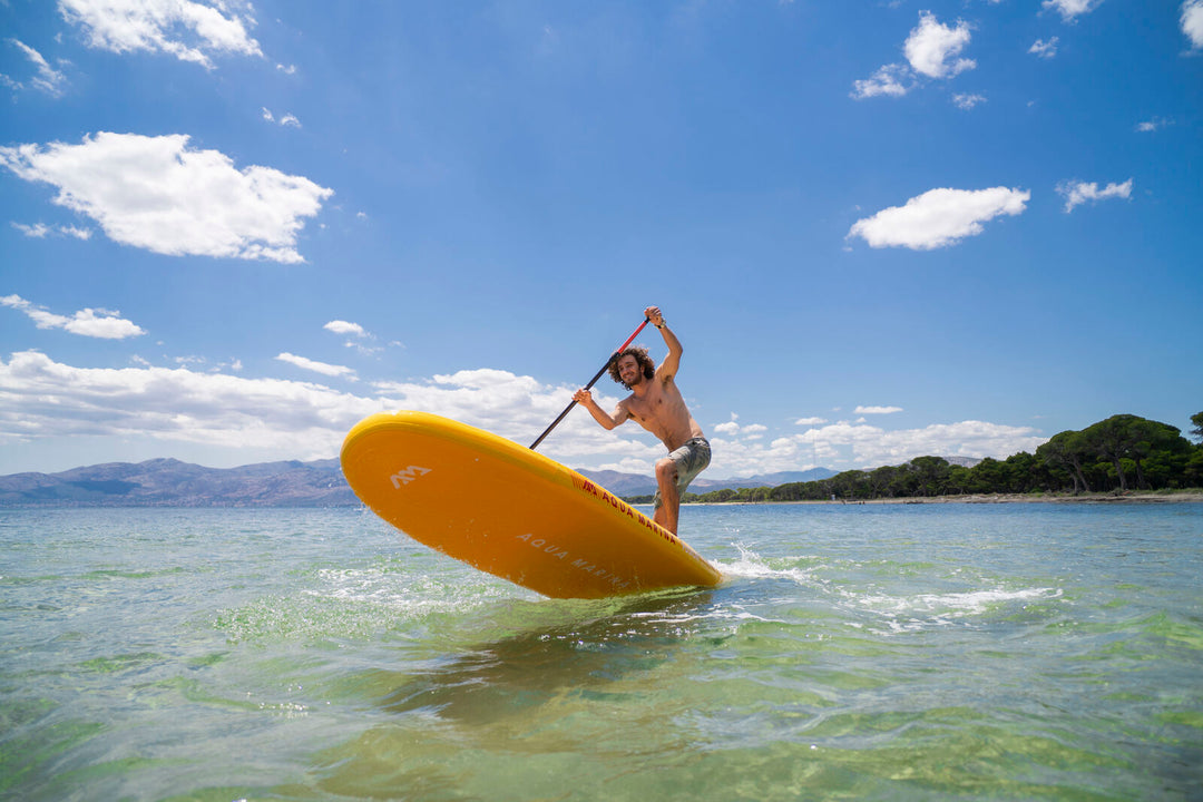Paddler doing a pivot turn on the Aqua Marina Fusion all-around SUP in clear shallow water