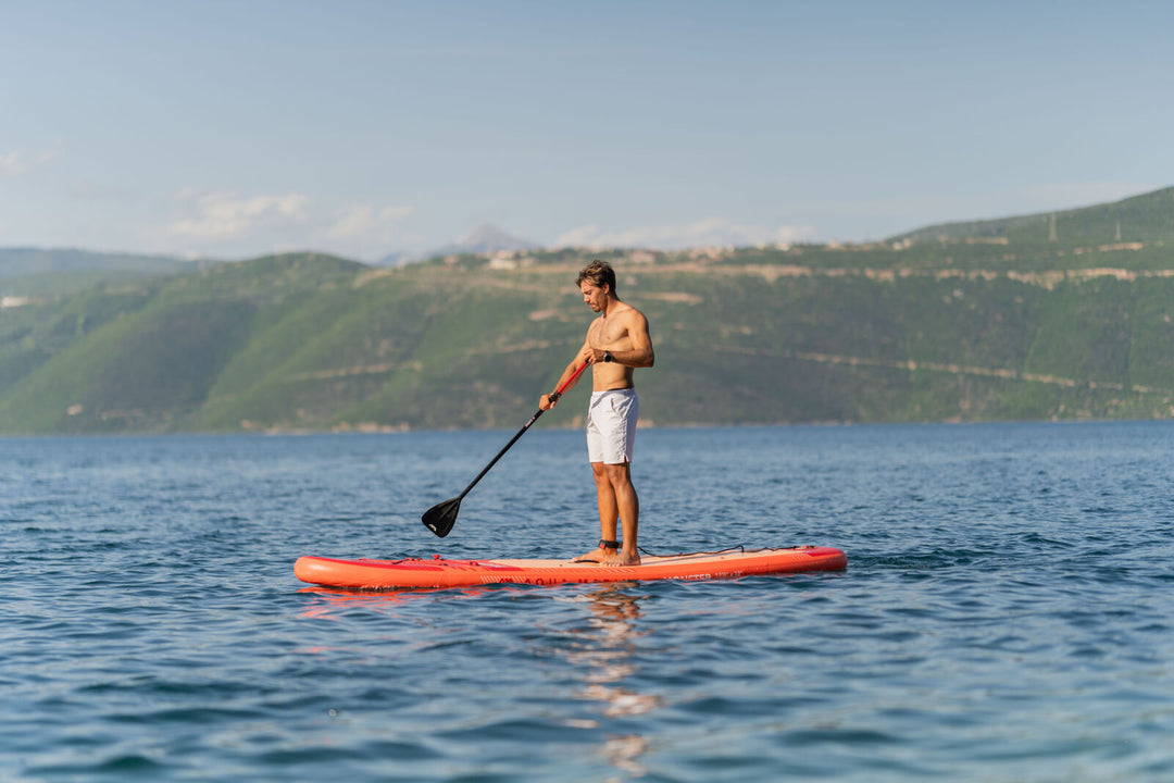 Man stand-up paddling on the 2026 Aqua Marina Monster 12'0" inflatable SUP on calm water