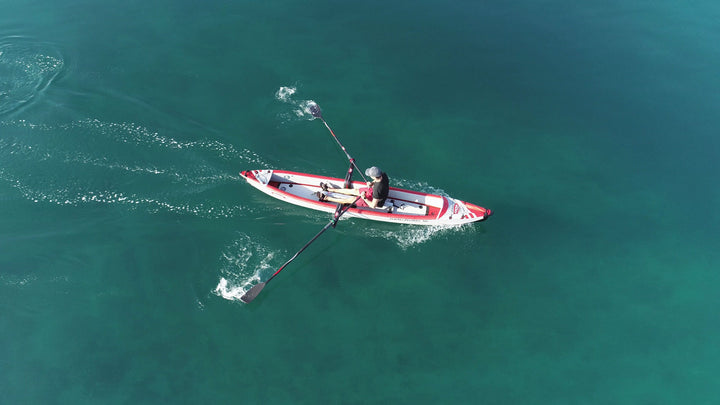 Rower sculling an AIRKAYAK 16 with the RowMotion deep outrigger rowing system