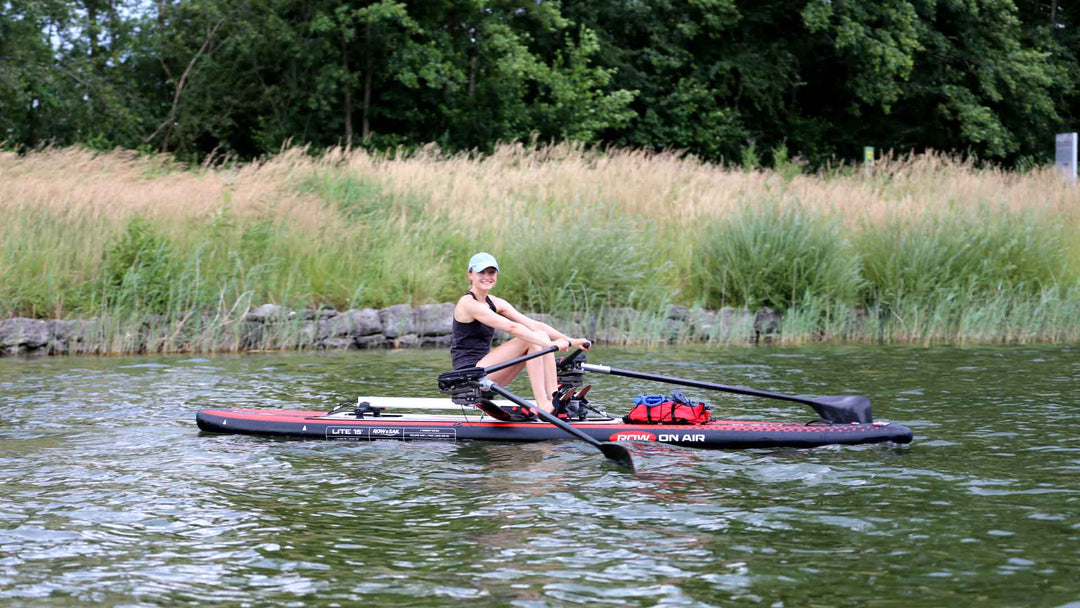 Rower sculling a ROWonAIR LITE 15 inflatable rowing board on flat water