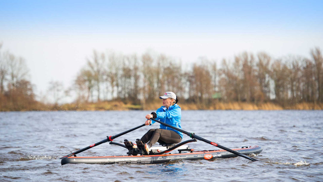 Rower sculling a ROWonAIR MOJO 18 inflatable rowing board on open water