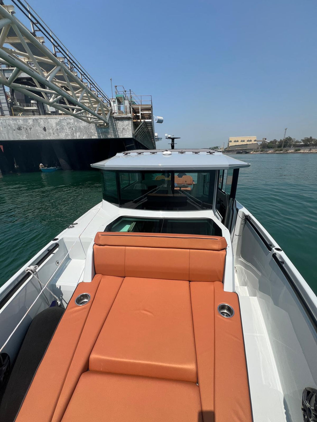 Saxdor 320 GTC bow sun pad and forward seating looking aft toward the enclosed wheelhouse