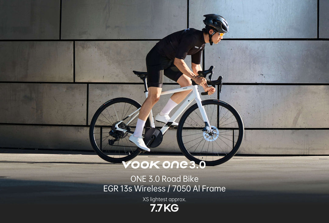 Cyclist riding the white VOOK ONE 3.0 past a concrete wall, 7.7 kg XS