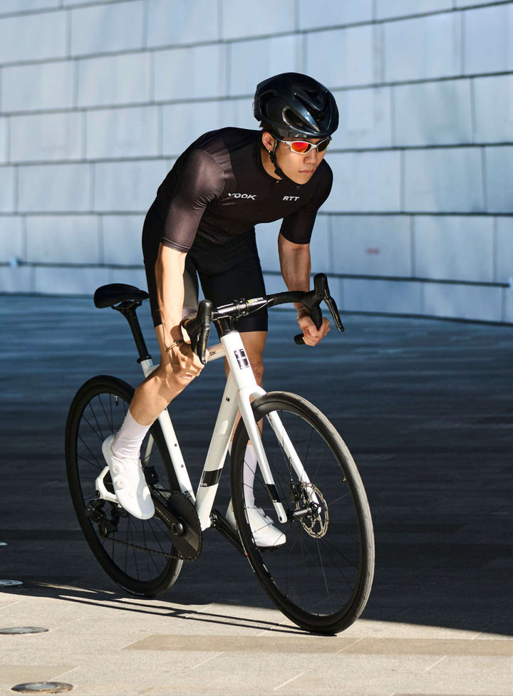 Rider cornering on a white VOOK ONE 3.0 road bike